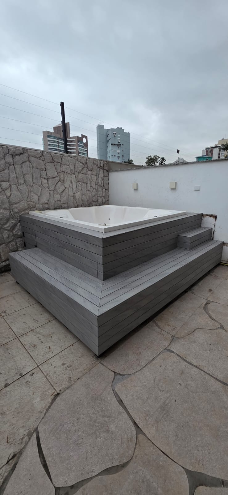 Spa em deck cinza em terraço urbano