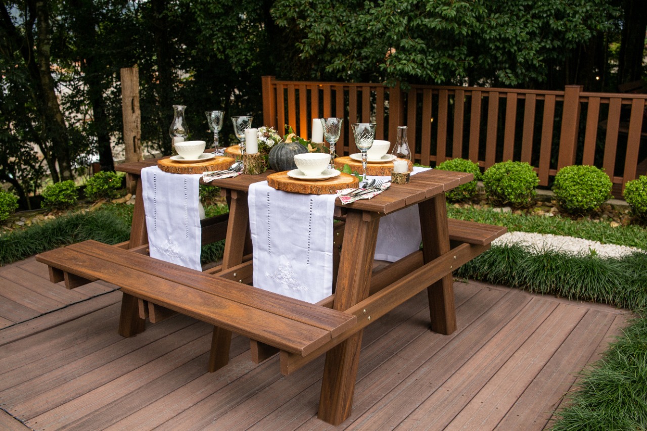Mesa de piquenique em madeira plástica posta para refeição em jardim