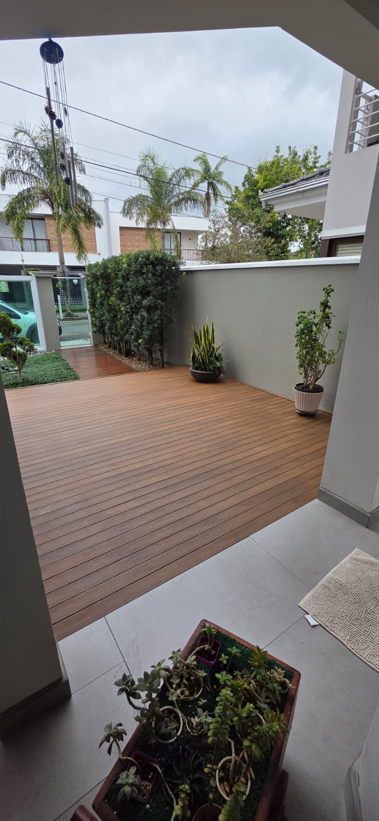 Deck em entrada residencial com paisagismo